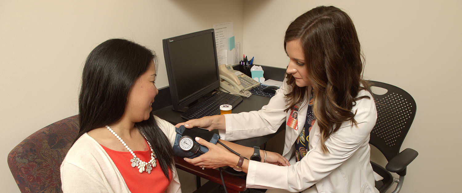 Pharmacist checks patient's blood pressure