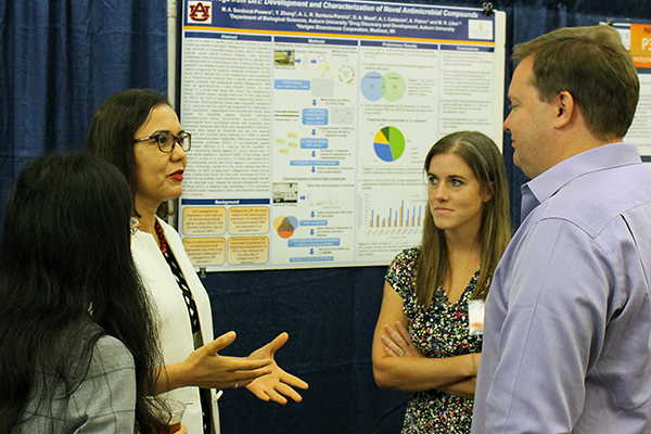 faculty and students discuss a poster