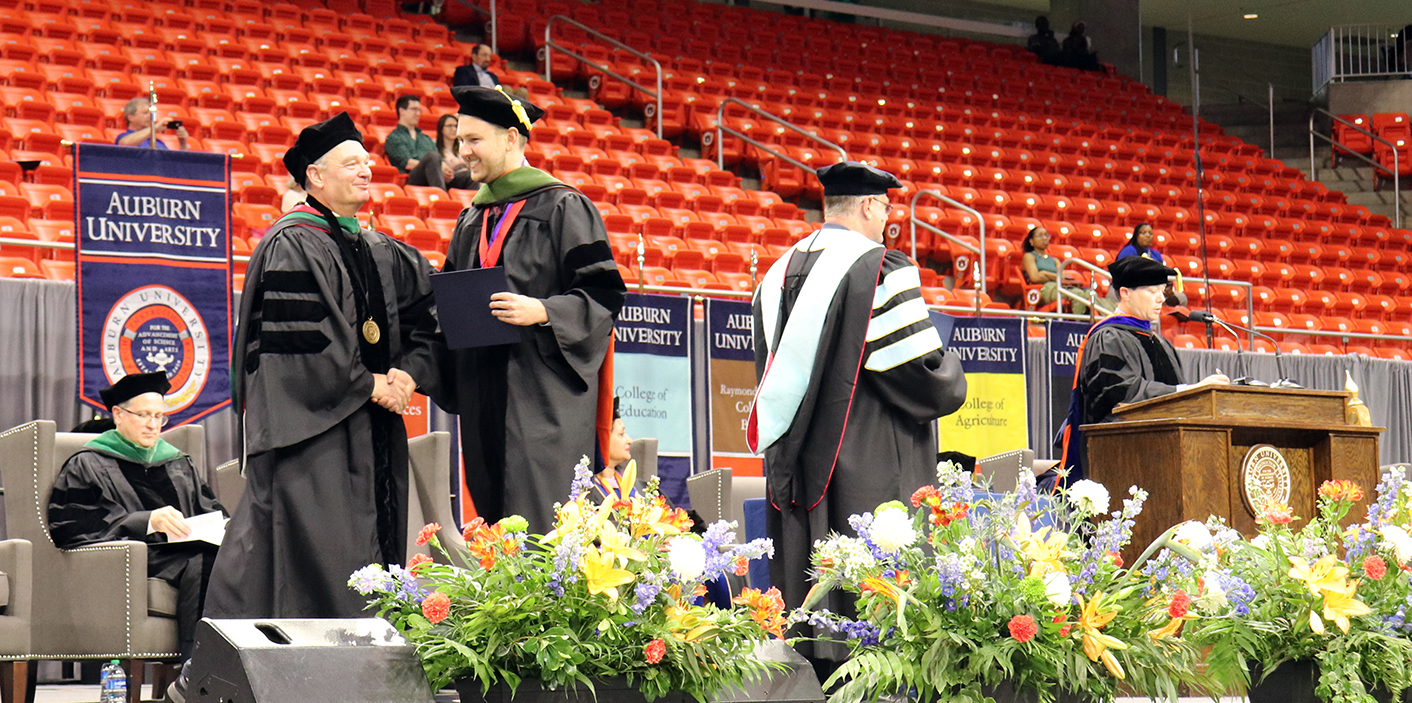 Graduate shakes hands with professor on stage