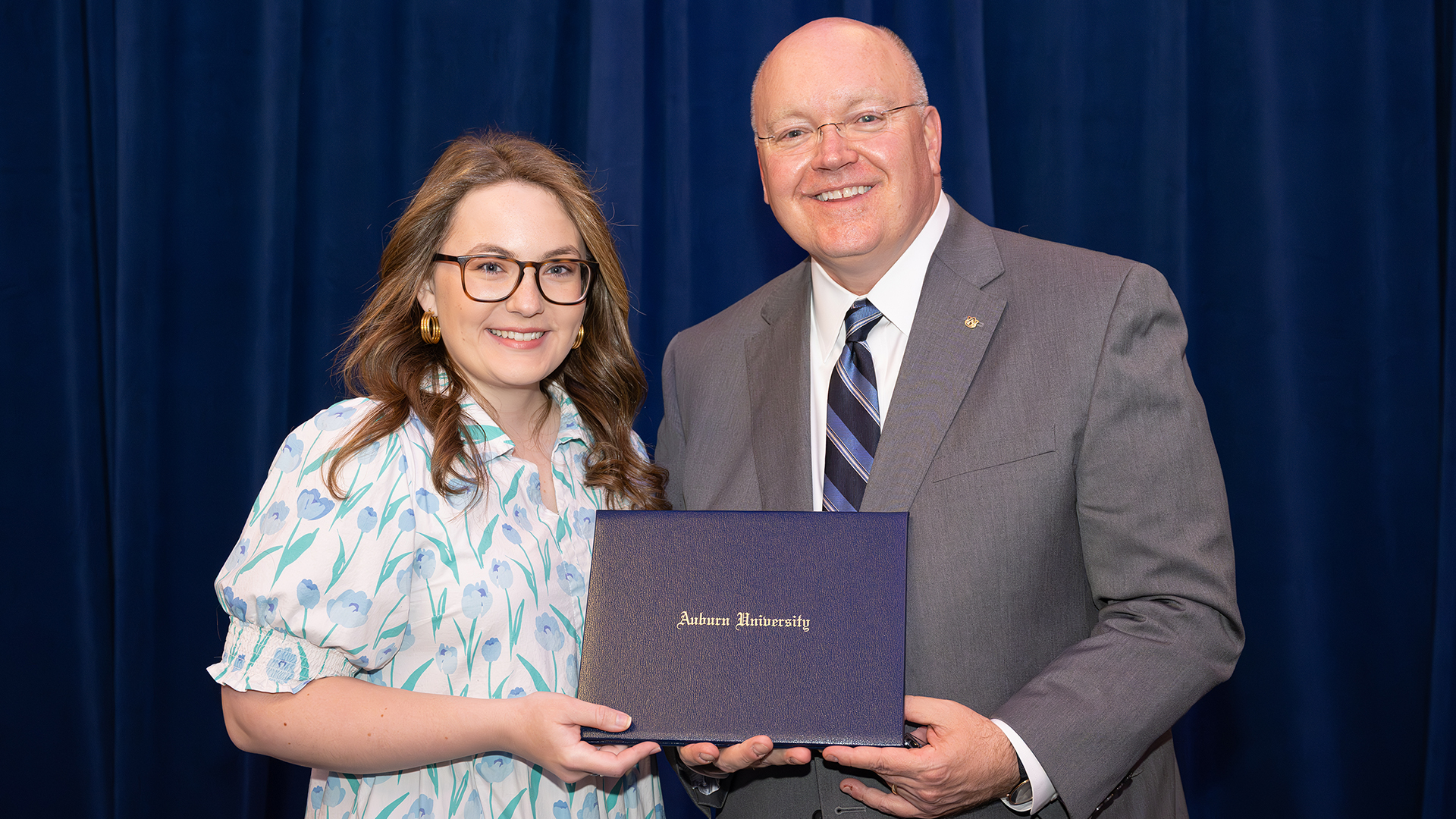 Two people stand with certificate