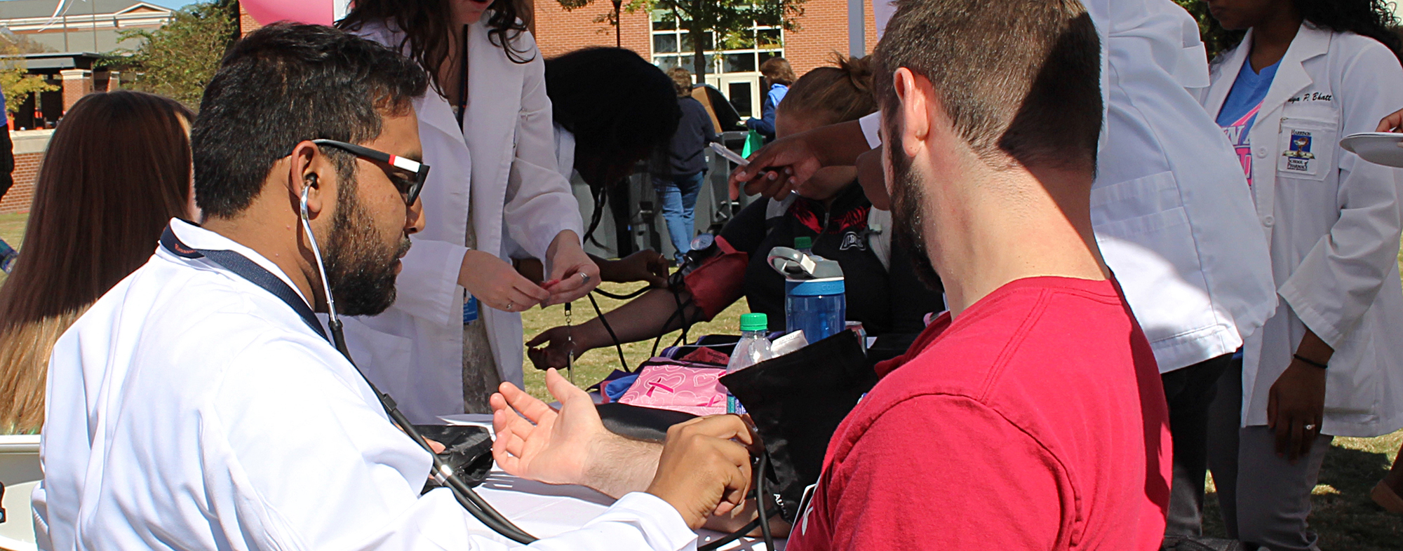 Student administering blood pressure check on patient